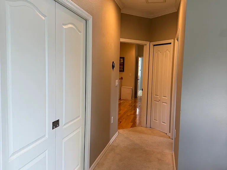 Primary Bedroom with double pocket doors to a spacious closet with vanity and his and hers walk-in closets and en suite bathroom on the right.