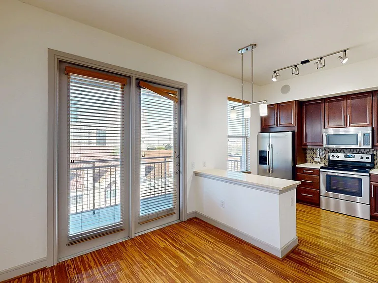 Apartment Kitchen with Stainless Steel Appliances, Dining and Living Room with Wood Style Flooring