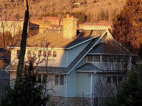 This is the back of the house. It shows the sunroom to the right and the wall of windows in the back is all part of the same upstairs apt. You will notice the Grove Park Inn in the back ground. That is what you see from the balcony on the front of the hou