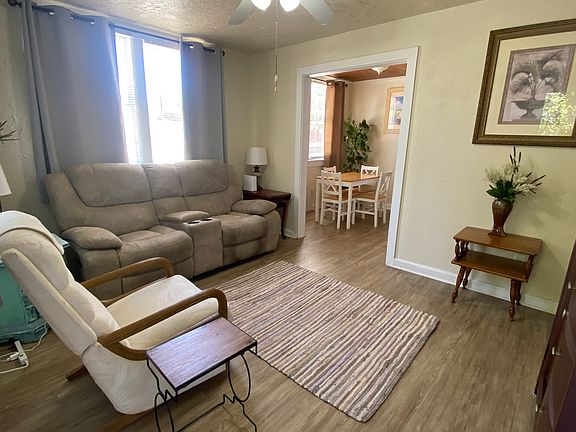 Living room has dual reclining loveseat, Lazy Boy recliner, vinyl plank flooring.