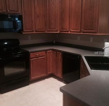 Kitchen showing 42 inch cabinets and black appliances