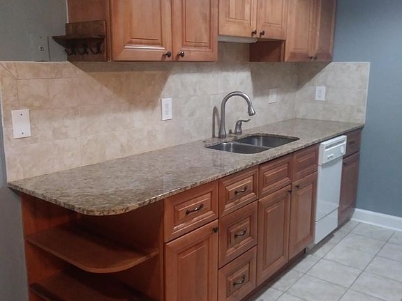 Tall cabinets and Dishwasher with undermount sink and granite countertops