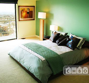 Master bedroom with gas fireplace, view of city and balcony