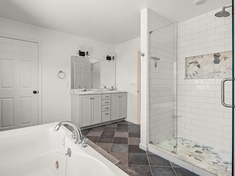 Primary bathroom and entrance to one of two primary bedroom walk-in closets.