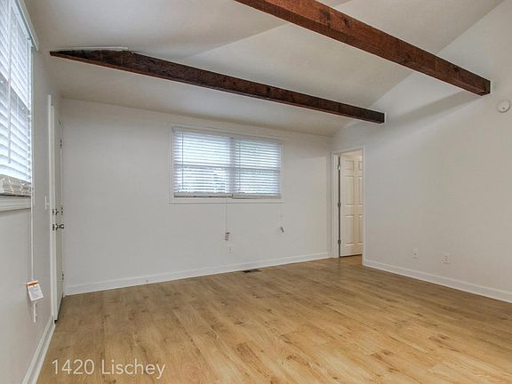 Living area with large trees outside the window. Hardwood floors