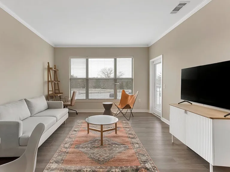 Furnished+ apartment homes come outfitted with a sofa, side chair, side table, coffee table, TV stand and 50" Television (Representative Image exact items and style of furnishings may vary)