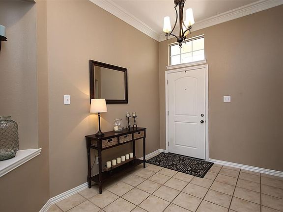 The entry is spacious, warm and inviting. It's also light and bright with an elegant pendant light and transom window above the door.