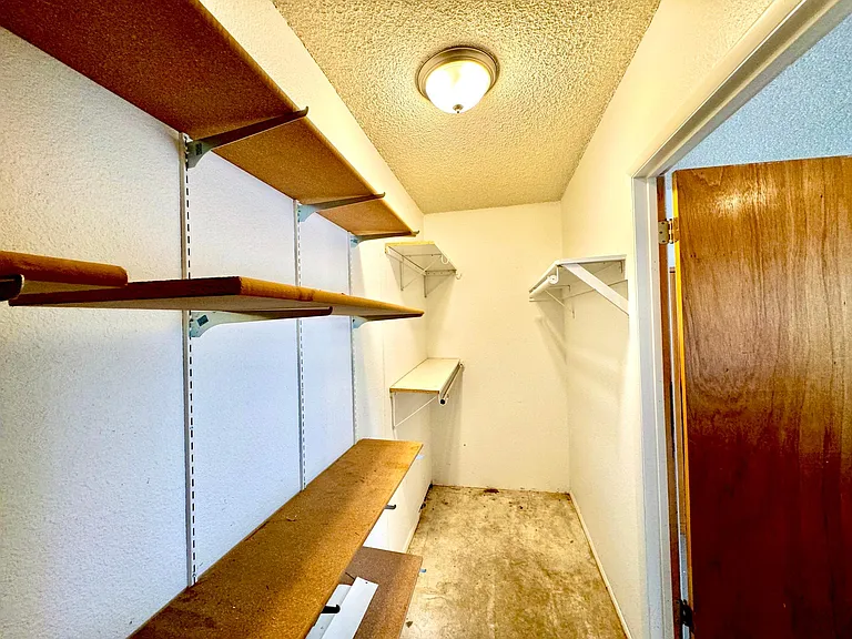 Storage room inside double garage with built in shelves.