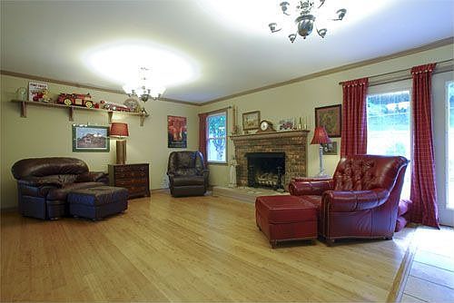 Den with stunning bamboo flooring and fireplace.