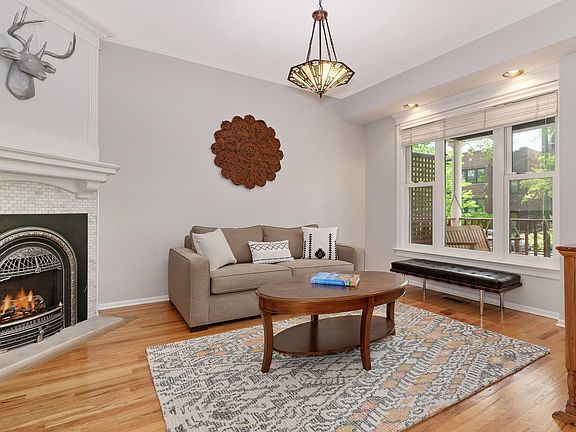 Beautiful living room with elegant gas fireplace with stone surround and white mantle