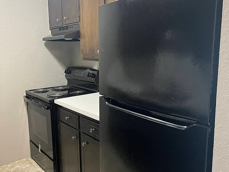 Kitchen with black appliances at Whispering Isle.