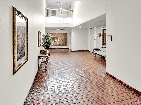 Welcoming building lobby with elegant tile flooring and tasteful decor.