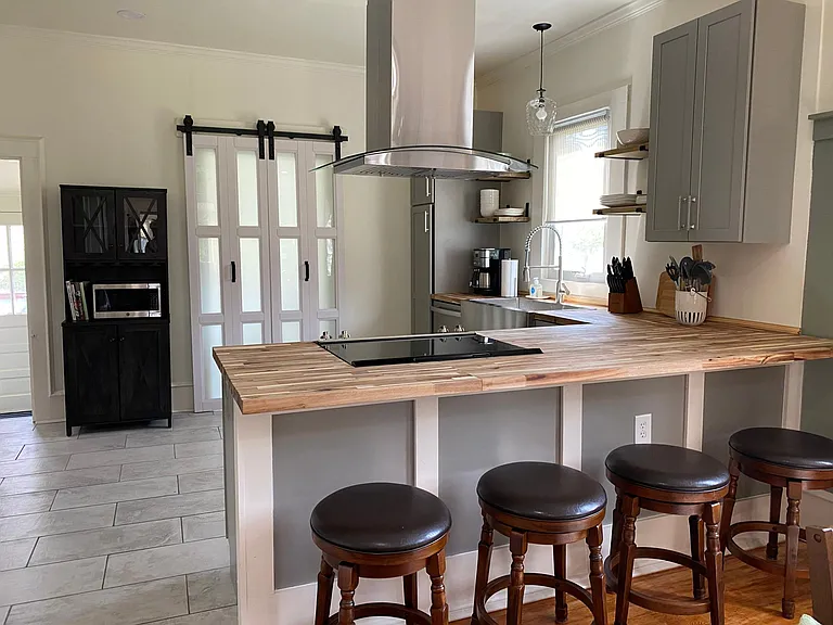 Swivel stools at the kitchen counter. Doors at the back lead to the laundry room.