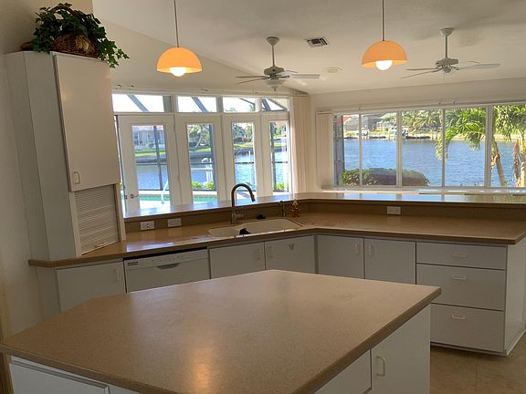 Large kitchen with dishwasher, refrigerator, glass cooktop, garbage disposal.