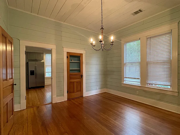 Dining room featuring a China Cabinet with beadboard and a chandelier.