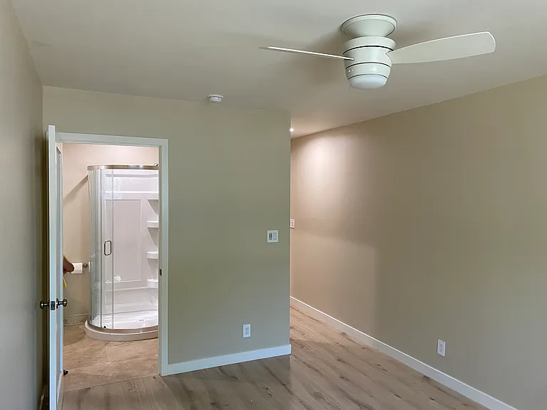Bedroom 2 View to shared bath and hallway / New Cabinet / shower / toilet / Privacy Glass doors to allow daylight in / Sensor humidity fan