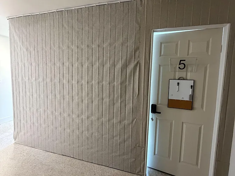 Interior hallway with easy-care flooring and a labeled entry door, providing convenient access to adjacent rooms.