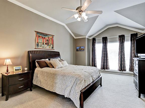 Huge master suite on the third floor has interesting architectural lines, crown moulding, ceiling fan, and a full wall of windows!