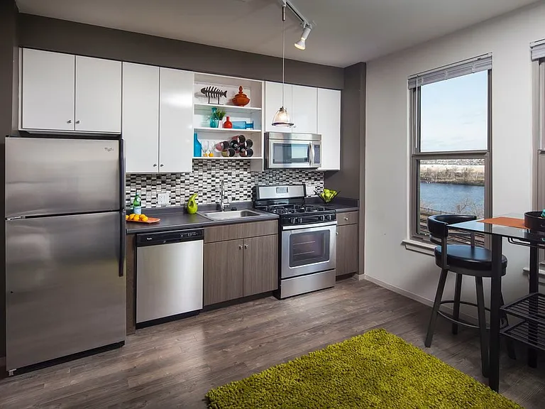 Classic Package II kitchen with stainless steel appliances, dark laminate countertops, white and brown cabinetry, tile backsplash, and hard surface flooring