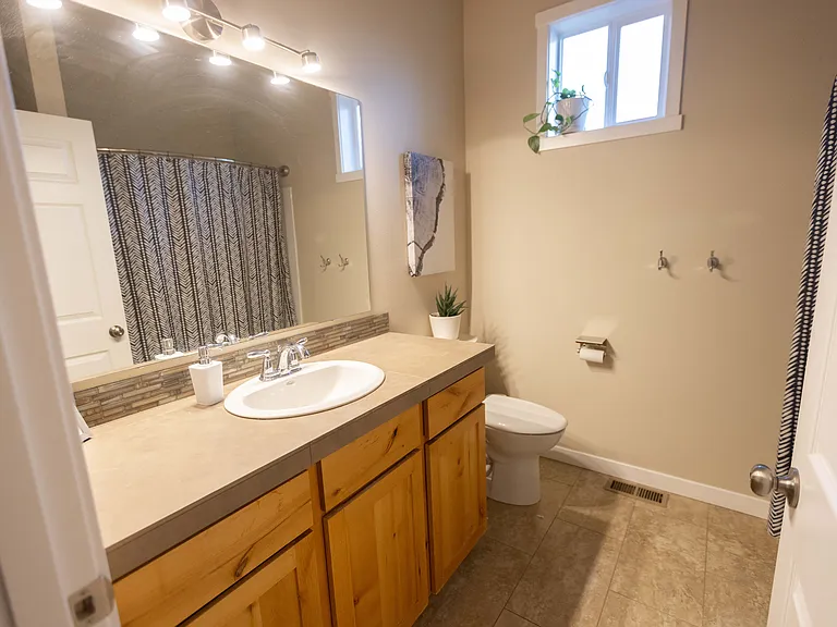 Guest full bathroom contains one sink, shower/tub combo