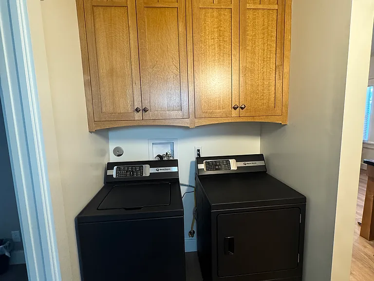 Laundry room with custom oak cabinets and Speed Queen washing machine and gas clothes dryer