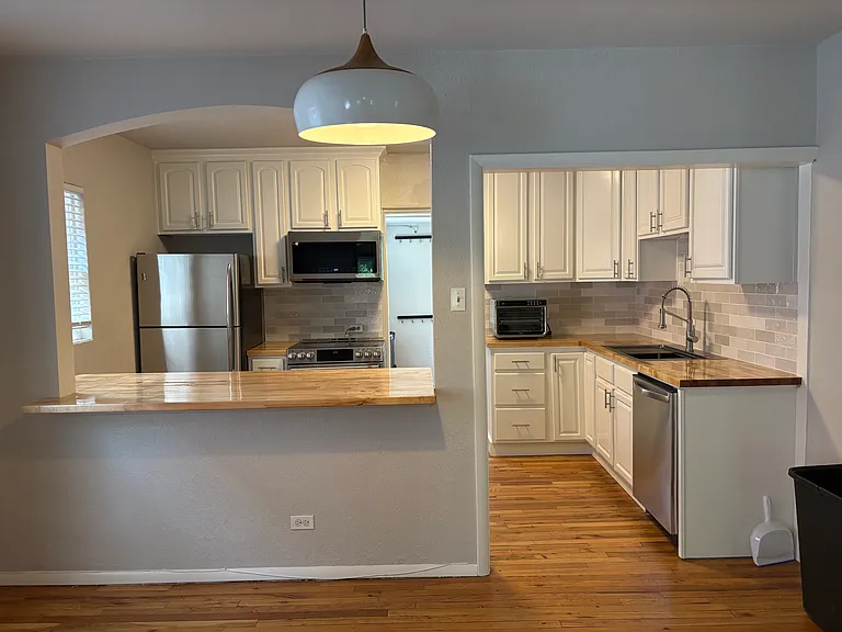 view from dining area to kitchen, new dishwasher, sink, microwave and fairly new induction stove.