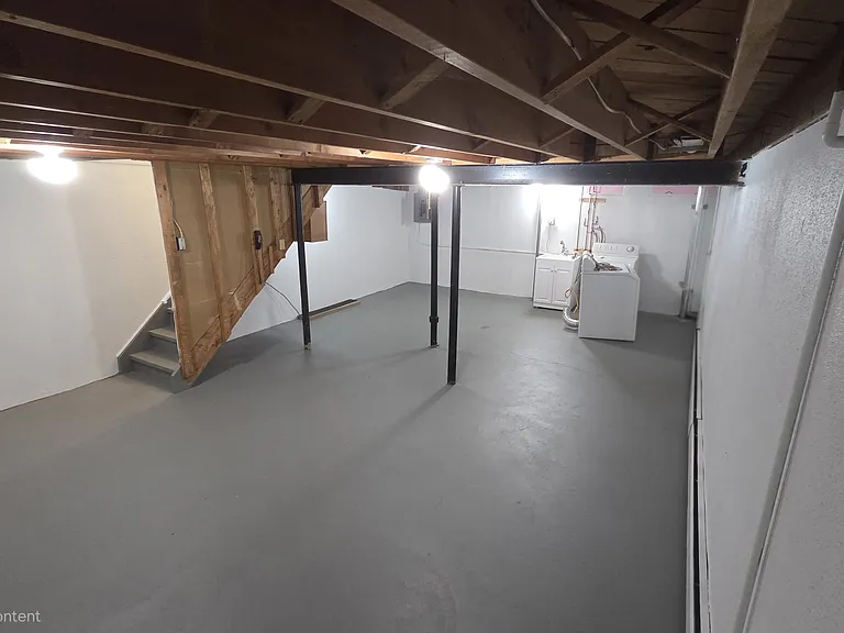 Spacious lower-level flex and laundry area with bright lighting and open storage potential.