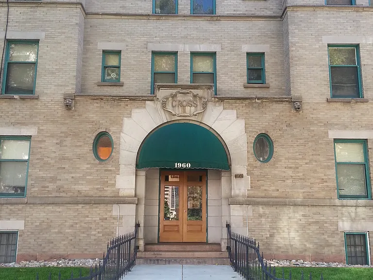 Historic brick apartment facade with green awnings and well-maintained entrance.