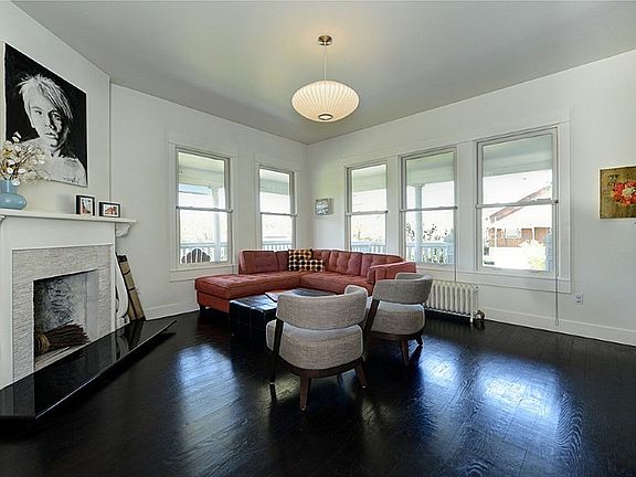 Main floor living area, fireplace, walls of windows looking out to the wrap around porch.