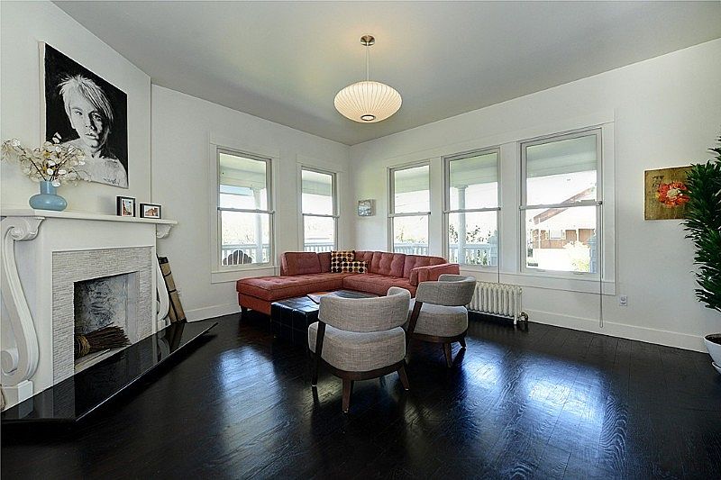 Main floor living area, fireplace, walls of windows looking out to the wrap around porch.