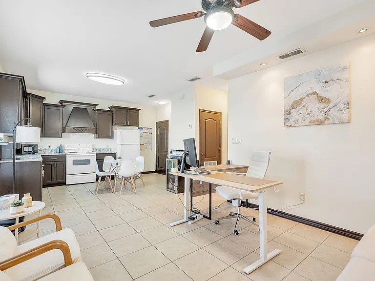 Modern kitchen and living room with a ceiling fan, showcasing the interior of Merida Vista Apartments in Laredo, Texas