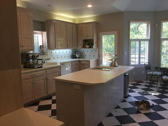 The updated kitchen features a new stainless dishwasher and a fairly new stainless refrigerator. Electric cooktop in island. Well lit with lots of windows and deck for morning coffee.