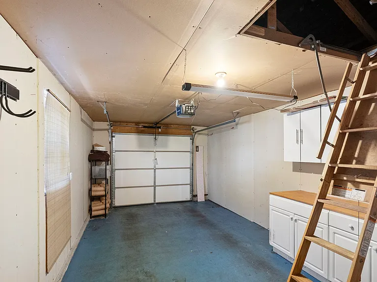 Garage with built-in cabinets and workbench, and full-length attic for additional storage