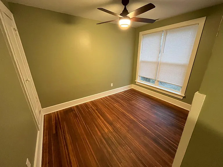 Small bedroom or office in the rear with generous natural light from two large windows.