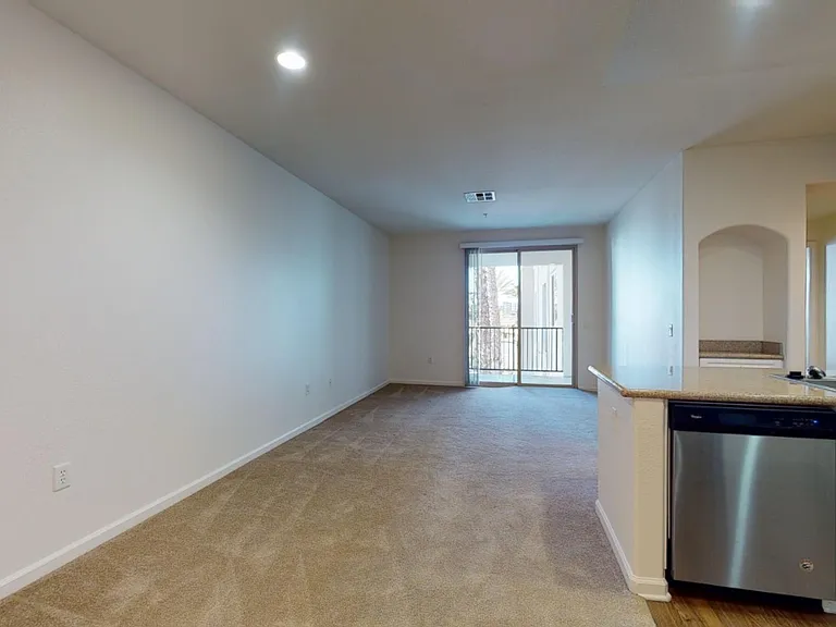 Apartment living room with plush carpet flooring.