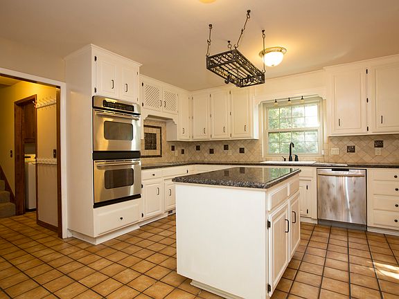 Newer stainless steel appliances enhance the updated Kitchen w/double ovens, Samsung dishwasher, glass cooktop w/downdraft & negotiable fridge! Back Hall provides stairway to Game Rm plus Utility Rm w/deep sink, folding counter & door to backyard.