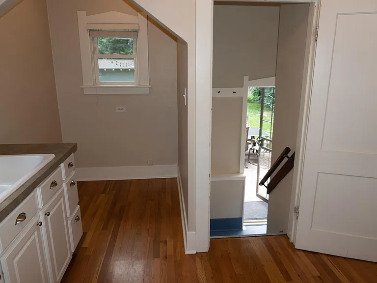 Entering kitchen from the living room. The kitchen nook is on the left. The stairs to the back door landing is to the right.