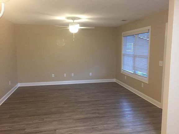 Spacious living area with ceiling fan.