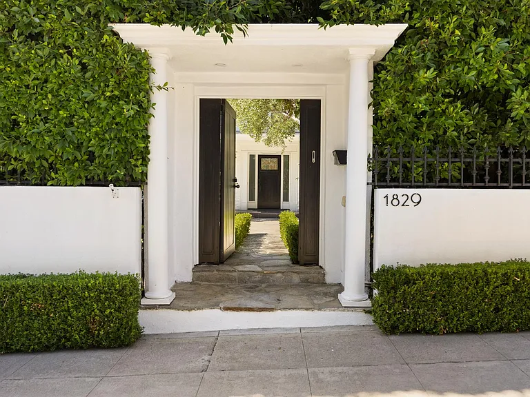 White pillars frame the grand entrance, guiding you along the luxurious walkway.