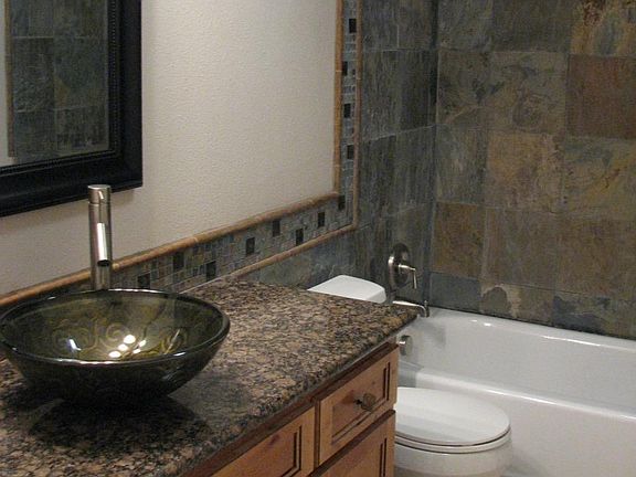 Upgraded bath with stone tile and granite countertops.