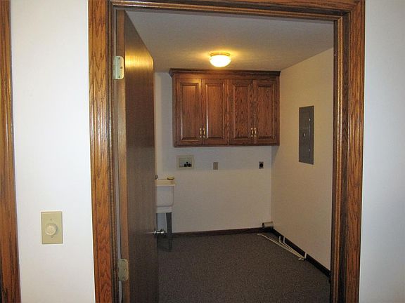 First floor laundry room with custom cupboards, hookups, and