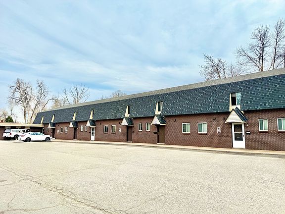 Charming apartment building with unique architecture, ample parking, and a serene neighborhood setting.