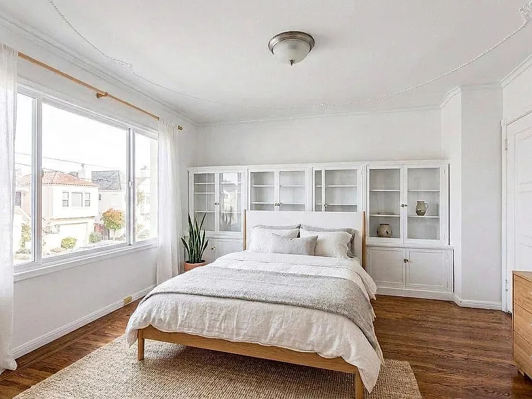 1 of 4 bedrooms with period built-in wall of cabinets, glass door access to 2nd floor deck and closet. (styled with ai)