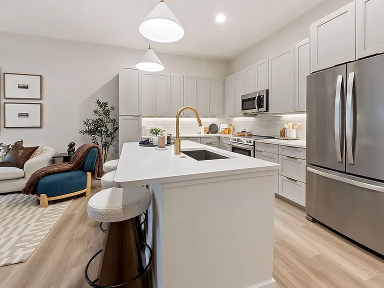 Upscale living starts in the kitchen: premium quartz countertops, stainless steel appliances, and designer lighting creates a space that is both stylish and functional