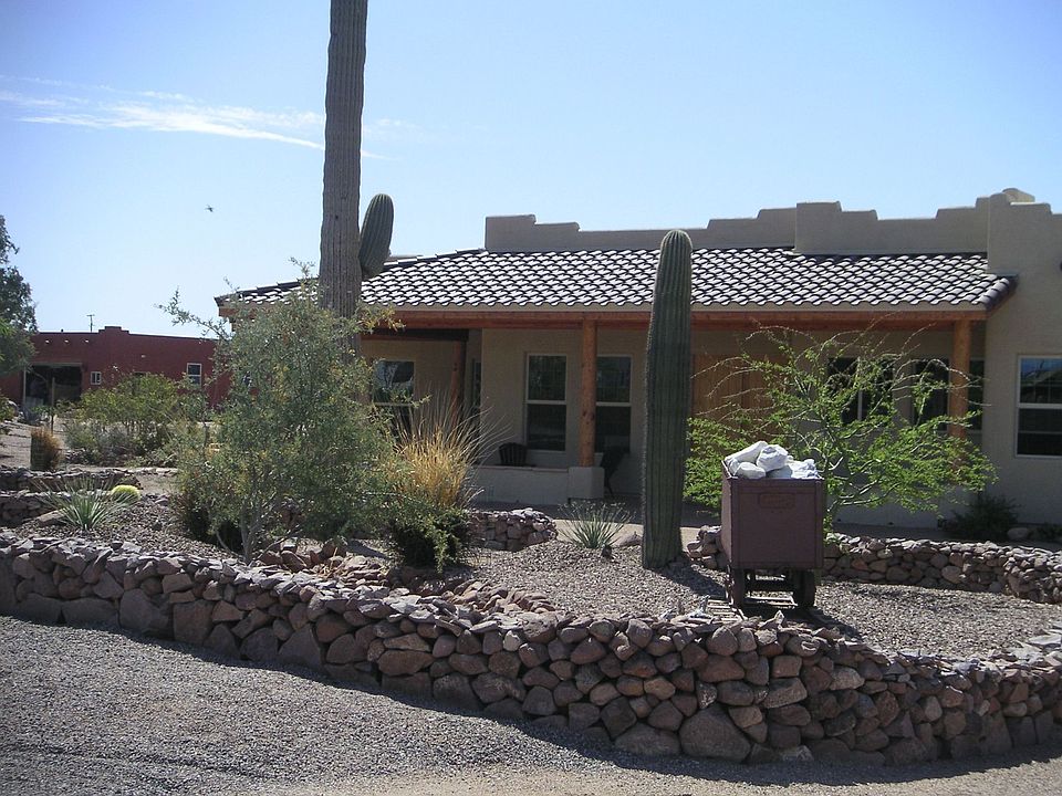 Front of home fully landscaped with circular driveway