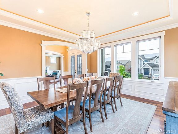 Formal dining room mirrors formal living with backlit tray ceiling, extensive woodwork and Brazilian Cherry hardwood floors