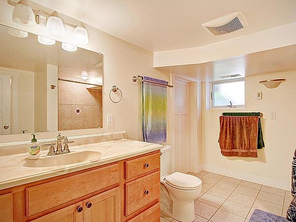 View of full bathroom with tub/shower, laundry room entrance next to the window