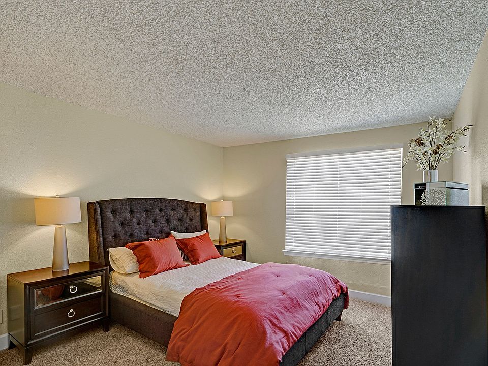 A bedroom with a wide window overlooking the property