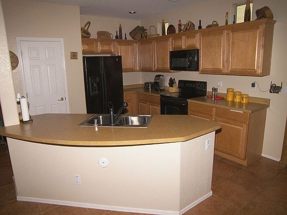 Kitchen with tile flooring, maple cabinets with crown molding