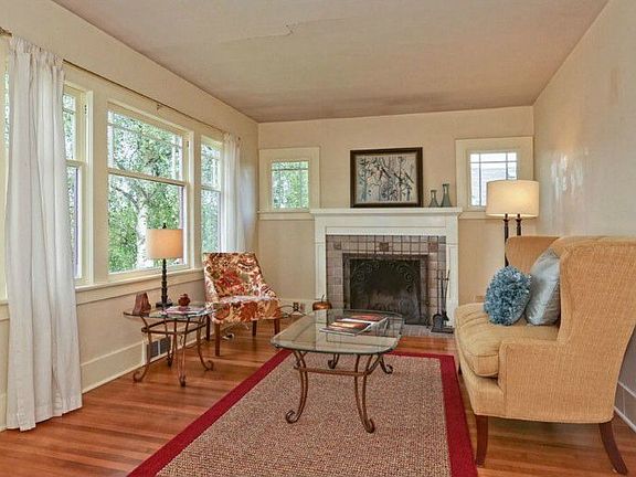 A very charming and light filled living room. There are oak floors and a pleasant treed outlook.